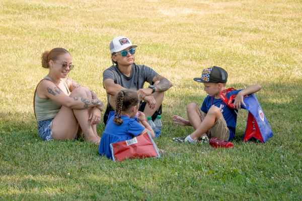 A family enjoys a quiet moment in the shade during a full day of festivities.